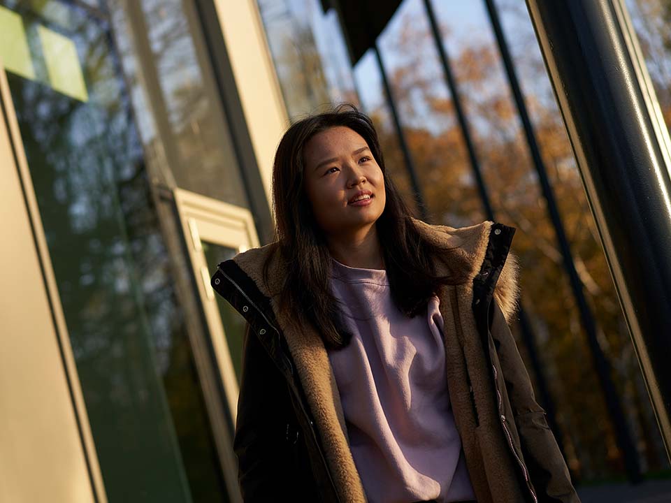 A female student exits the GRID building, London Campus